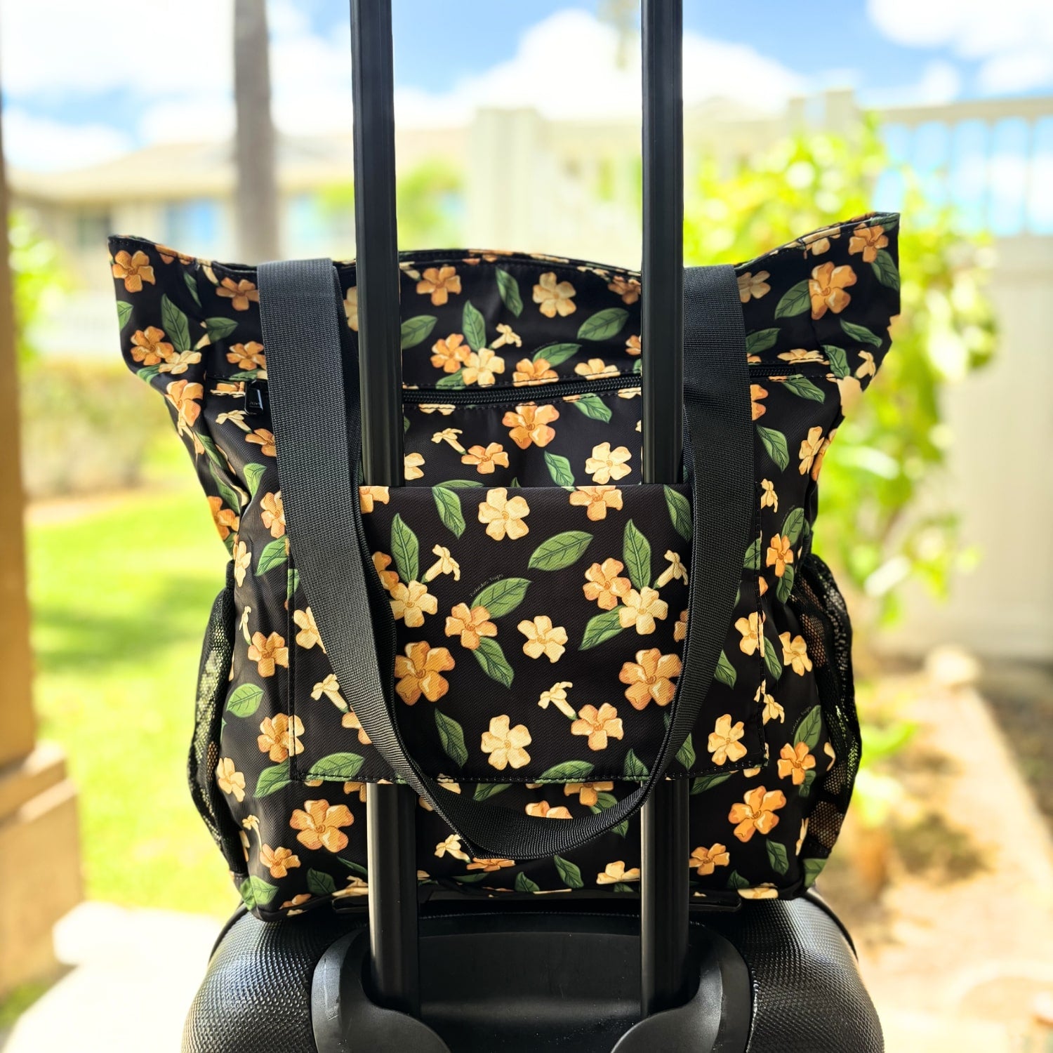 Holoholo bag with pua kenikeni flowers and leaves from Puakenikeni Designs on carry on rolling luggage for travel back view