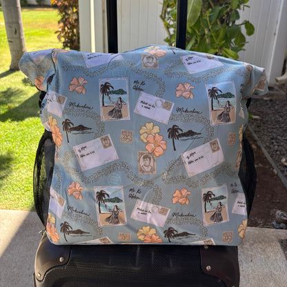 Pua kenikeni Holoholo Bag for travel with crossbody strap from Puakenikeni Designs - use for beach, diaper bag, handbag, hula bag from Puakenikeni Designs on a suitcase