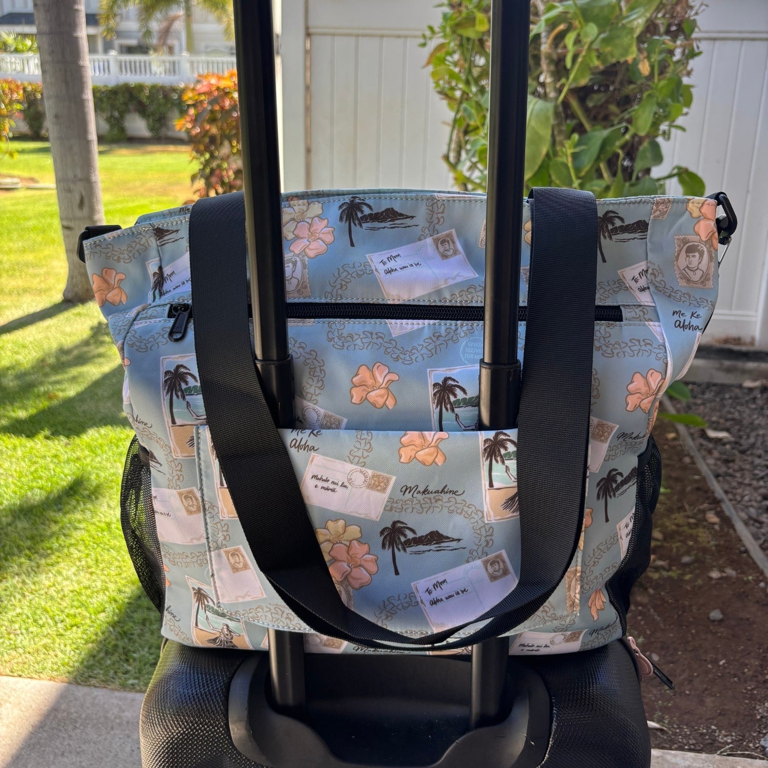Pua kenikeni Holoholo Bag for travel with crossbody strap from Puakenikeni Designs - use for beach, diaper bag, handbag, hula bag from Puakenikeni Designs on a suitcase showing back strap