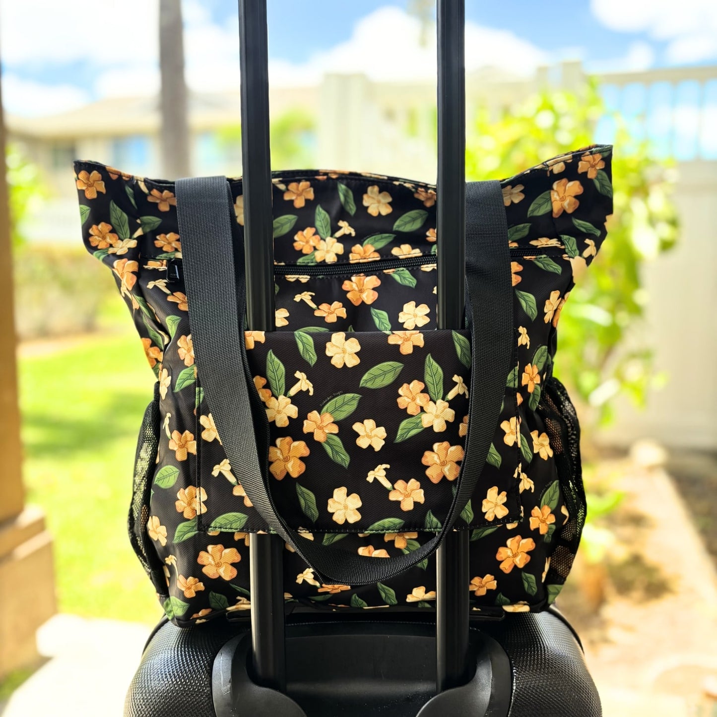 Holoholo bag with pua kenikeni flowers and leaves from Puakenikeni Designs on carry on rolling luggage for travel back view